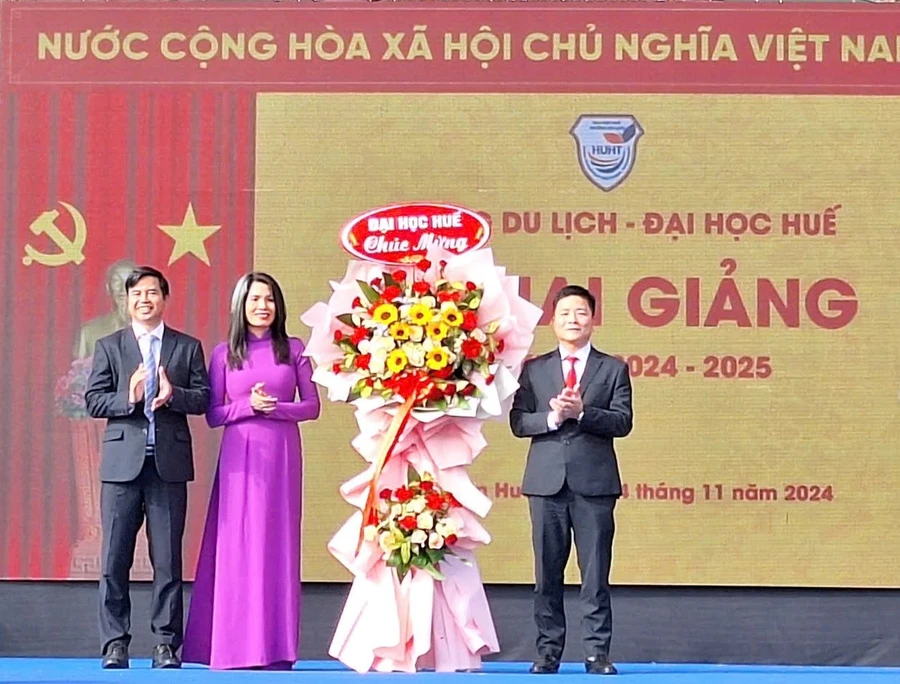 TS Bùi Văn Lợi, Phó Giám đốc Đại học Huế (bìa phải) tặng hoa chúc mừng Ban Giám hiệu Trường Du lịch - Đại học Huế tại lễ khai giảng. (Ảnh: Đại Dương)