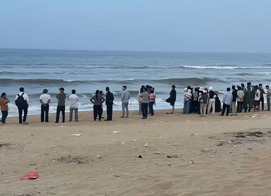 Người nhà nạn nhân và lực lượng chức năng, người dân đứng trên bờ biển Vinh Thanh tìm kiếm. (Ảnh: T.H)