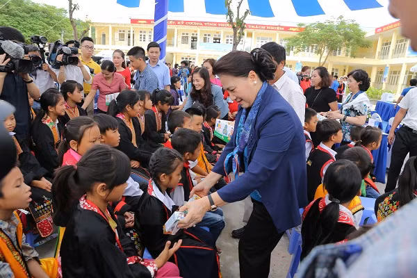 Chủ tịch Quốc hội Nguyễn Thị Kim Ngân trao sữa cho các em học sinh tại chương trình.