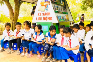 Học sinh đọc sách, truyện dưới tán cây xanh là cách nâng cao văn hóa đọc tại Trường Tiểu học - THCS A Xing. Ảnh: NTCC