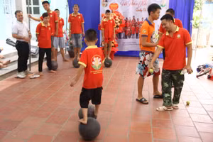 Thầy Vũ Văn Chức hướng dẫn trẻ tự kỷ di chuyển bằng bóng. Ảnh: TG