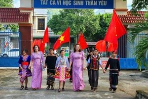 Học sinh miền núi Đắk Lắk đến trường trong vòng tay thầy cô. Ảnh tư liệu