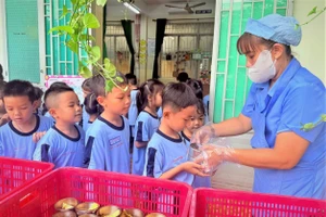 Học sinh Trường Tiểu học Thuận Kiều (phường Đông Hưng Thuận) trong bữa ăn bán trú. Ảnh: MA