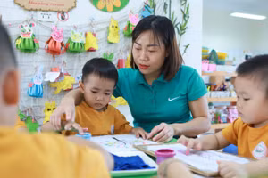 Cô Bùi Thị Thu Hà - giáo viên Trường Mầm non An Khánh B (Hoài Đức, Hà Nội) hướng dẫn trẻ sử dụng màu vẽ tranh. Ảnh: TG