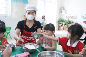 Nhân viên nuôi dưỡng tại Trường Mầm non Hoa Sơn (Ứng Hòa, Hà Nội) cho trẻ ăn trưa. Ảnh: Khôi Nguyên