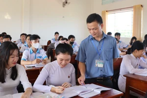 Thầy Hồ Minh Tình hướng dẫn học sinh làm bài. Ảnh: Quách Mến