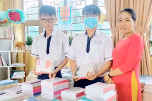 Cô Lang tặng sách cho học sinh. Ảnh: Phạm Ngọc