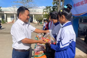 Thầy Vũ Văn Tùng - Trường Tiểu học và THCS Đinh Núp (Gia Lai) mang những phần quà đến học sinh vùng khó.