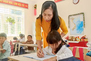 Cô giáo Lê Thị Oanh nắn nót từng nét chữ cho học sinh.