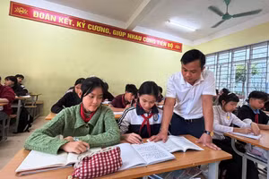 Thầy giáo Hà Văn Dàn và học sinh của mình ở Trường TH&THCS Mường Lát. Ảnh: Thế Lượng