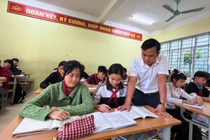 Thầy giáo Hà Văn Dàn và học sinh của mình ở Trường TH&THCS Mường Lát. Ảnh: Thế Lượng