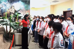 Học sinh Trường THCS Thanh Nưa nghe thuyết minh về các hiện vật, quá trình đấu tranh của quân và dân ta trong chiến dịch Điện Biên Phủ. Ảnh: Thu Hằng