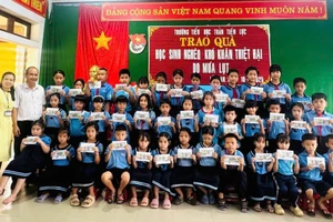 Tác giả thay mặt nhà hảo tâm tặng quà sau lụt cho học sinh bị thiệt hại sau cơn lũ cuối tháng 10 tại Trường Tiểu học Trần Tiến Lực, TP Huế. Ảnh: NVCC