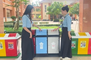 Sinh viên tìm hiểu về thùng phân loại rác tại sự kiện “Dệt xanh” năm 2025. Ảnh: Thùy Linh