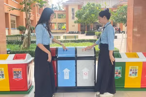 Sinh viên tìm hiểu về thùng phân loại rác tại sự kiện “Dệt xanh” năm 2025. Ảnh: Thùy Linh