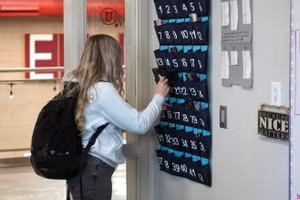 Một nữ sinh cất điện thoại di động trước giờ học tại Trường Trung học Delta (Mỹ). Ảnh: AP