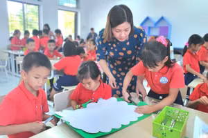 Giáo viên Trường Tiểu học Rạng Đông (Ninh Bình) hướng dẫn học sinh thực hành làm sản phẩm STEM “Cây gia đình”. Ảnh: NTCC