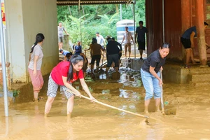 Giáo viên Trường Phổ thông DTBT Tiểu học Lượng Minh dọn dẹp sân trường sau lũ quét vào đêm 30/9. Ảnh: Phạm Tâm