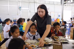 Cô Dung lấy cơm cho các em. 