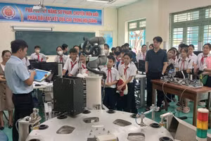 Học sinh Trường THCS Hồ Nghinh (Hải Châu, Đà Nẵng) tìm hiểu mô hình robot và hệ thống điện tái tạo tại phòng thực hành, Trường Cao đẳng Lương thực - Thực phẩm Đà Nẵng. Ảnh: NTCC