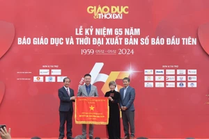 Bộ trưởng Nguyễn Kim Sơn trao Cờ thi đua của Chính phủ cho Báo Giáo dục và Thời đại dịp kỷ niệm 65 năm ngày Báo Giáo dục và Thời đại xuất bản số báo đầu tiên. Ảnh: Trần Hiệp