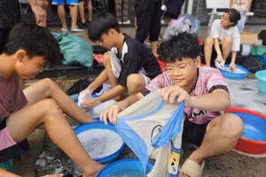 Học sinh Trường nội trú Hy vọng giặt sạch áo quần để phân loại trước khi gửi tặng các bạn vùng lũ. Ảnh: NTCC 