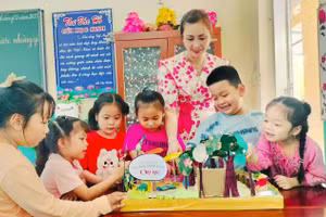 Học sinh Trường Tiểu học Nguyễn Đình Chiểu thích thú với mô hình chợ quê được làm từ rác thải bỏ đi. Ảnh: Quách Mến