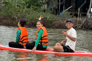 Nguyễn Trung Kiên chèo thuyền SUP đưa khách đi ngắm cảnh. 