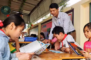 Thầy Đặng Xuân Viên - Hiệu trưởng Trường Tiểu học Thanh Xuân, xã Phú Xuân (huyện Quan Hóa, Thanh Hóa) và học sinh trong giờ đọc sách ở thư viện nhà trường.