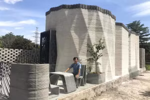 PGS.TS Trần Văn Miền bên ngôi nhà được tạo bằng công nghệ in 3D. Ảnh: NVCC