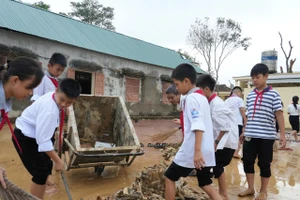 Học sinh Trường THCS Kỳ Tân, xã Tân Kỳ, Nghệ An tham gia dọn dẹp, vệ sinh sân trường sau lũ. Ảnh: Hồ Lài