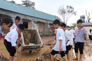 Học sinh Trường THCS Kỳ Tân, xã Tân Kỳ, Nghệ An tham gia dọn dẹp, vệ sinh sân trường sau lũ. Ảnh: Hồ Lài