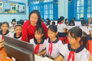 Cô giáo Trần Thị Huệ hướng dẫn học sinh thực hành môn Tin học. Ảnh: Đăng Đức