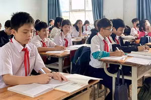 Một số học sinh bị hư hỏng sách giáo khoa trong đợt mưa lũ, phải dùng chung sách với bạn để chờ được hỗ trợ. Ảnh: Dung Nguyễn