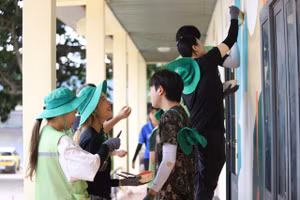 Sinh viên Hàn - Việt cùng các em nhỏ trang trí khuôn viên Trường Tiểu học Nguyễn Bá Ngọc. Ảnh: TT