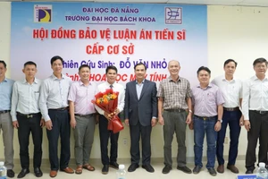 Thầy Đỗ Văn Nhỏ (cầm hoa) trong buổi bảo vệ luận án tiến sĩ cấp cơ sở ngành Khoa học máy tính tại Trường Đại học Bách khoa (Đại học Đà Nẵng). Ảnh: NVCC