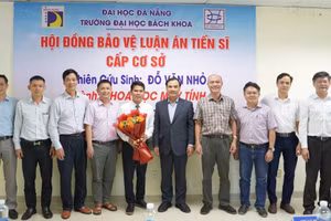 Thầy Đỗ Văn Nhỏ (cầm hoa) trong buổi bảo vệ luận án tiến sĩ cấp cơ sở ngành Khoa học máy tính tại Trường Đại học Bách khoa (Đại học Đà Nẵng). Ảnh: NVCC