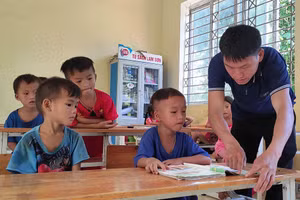 Giáo viên tại điểm lẻ Tà Cóm - Trường Tiểu học Trung Lý 2 (Thanh Hóa) hướng dẫn học sinh lớp 1 tập đọc.