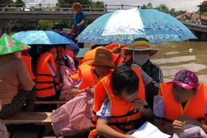 Học sinh ở vùng lũ ấp Phú Hiệp (Phú Hữu, An Giang) được đưa trở về nhà sau buổi học. Ảnh: T Hằng - N. Thanh