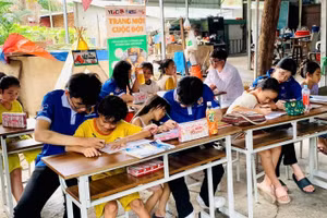 Các gia sư áo xanh dạy học cho trẻ tại “Lớp viết tiếp tương lai”. Ảnh: NVCC