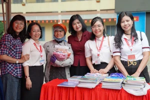 Cô Kim Lững (thứ 2 từ trái qua) cùng đồng nghiệp và phụ huynh tại “Phiên chợ 0 đồng”. Ảnh: MA