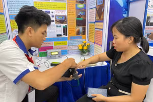 Thử nghiệm sản phẩm găng tay thông minh của nhóm học sinh Trường THCS Lưu Văn Mót. Ảnh: Hà An