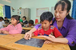 Cô Trần Thị Lệ hướng dẫn học sinh phép tính cộng.