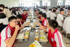 Học sinh Trường THCS Mai Dịch (Hà Nội) ăn bán trú tại bếp ăn nhà trường. 