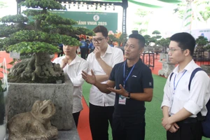 Ông Lê Đức Nam hướng dẫn sinh viên Học viện Nông nghiệp Việt Nam về chăm sóc, tạo thế cho cây cảnh. Ảnh: TG