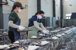 Nhân viên nuôi dưỡng tại Trường Tiểu học Kim Chung A (Hoài Đức, Hà Nội) chia thức ăn cho học sinh. Ảnh: Khôi Nguyên