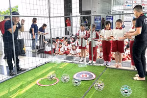Học sinh thích thú khi trải nghiệm trò chơi đá bóng trên không (drone soccer). Ảnh: SHTP-IC