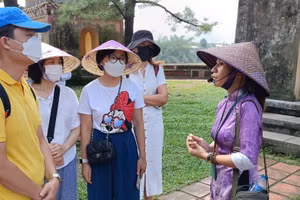 Hướng dẫn viên du lịch hướng dẫn cho khách tham quan tại di tích chùa Thiên Mụ (TP Huế). Ảnh: Quốc Hải 