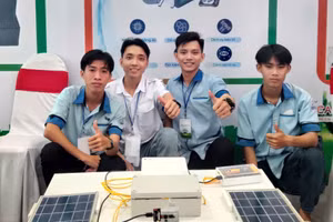 Nhóm sinh viên chụp ảnh bên mô hình robot vớt rác trên sông.