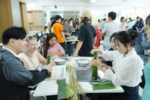 Sinh viên quốc tế Trường Đại học Sư phạm - Đại học Đà Nẵng trải nghiệm gói bánh chưng, bánh tét. Ảnh: NTCC